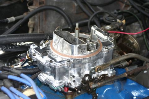 1976 Ford Ranchero - A close-up view of a shiny carburetor, likely part of a larger engine assembly, with some visible markings.