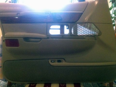 2001 Mercury Grand Marquis - Interior door panel from a car, showing trim, speaker grille, and reflector.
