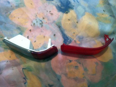 2001 Mercury Grand Marquis - Two detached car door lamps, one clear and white, the other red, are displayed on a colorful, patterned background.