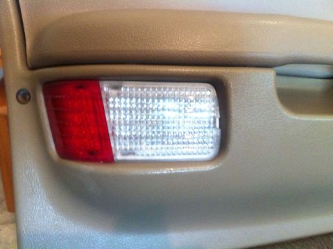 2001 Mercury Grand Marquis - Close-up of a vehicle's interior door panel showing a red and clear courtesy lamp.