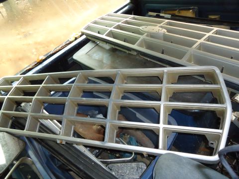 1985 Ford Bronco - Two vehicle grilles are visible, one in the foreground and another stacked behind it in a truck bed.