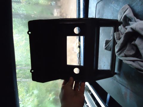 1985 Ford Bronco - This black dashboard trim piece features openings for gauges and the radio, likely from an older vehicle.