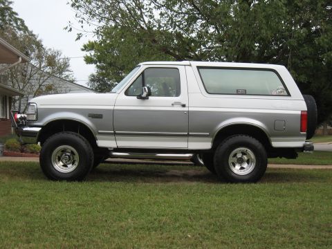 1994 Ford Bronco - Side view of a two-door Ford Bronco with a two-tone paint scheme and off-road tires.