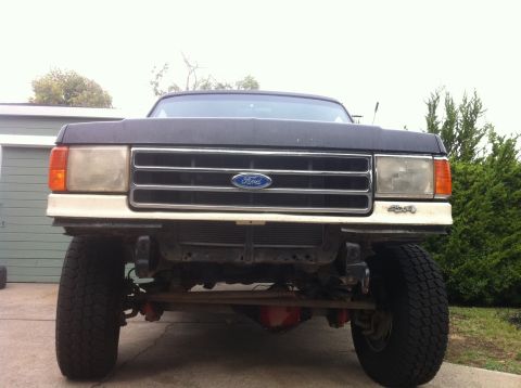 1989 Ford Bronco - Front view of a 1987 Ford Bronco, showing the grille and 4x4 badging.