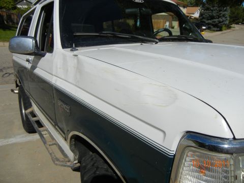 1996 Ford Bronco - This 1996 Ford Bronco shows some wear and tear, including a dent on the hood, but remains a recognizable classic SUV.