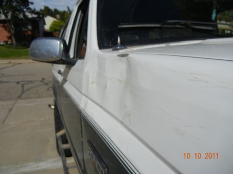1996 Ford Bronco - The vehicle has visible damage to the front fender and door, with scratches across the body panels.