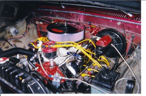 1978 Ford Bronco - Engine bay view of a V8 with a chrome round air cleaner, red MSD distributor, yellow spark plug wires, and a black brake booster, all set i…