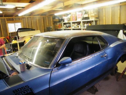 1970 Ford Mustang - 1970 Ford Mustang in a garage, showing the BOSS 302 decal and interior.