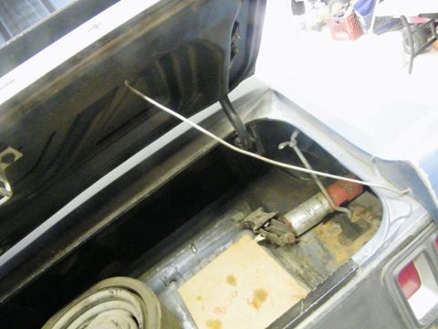 1970 Ford Mustang - The trunk of a 1970 Ford Mustang shows a spare tire well, jack, and a fire extinguisher.