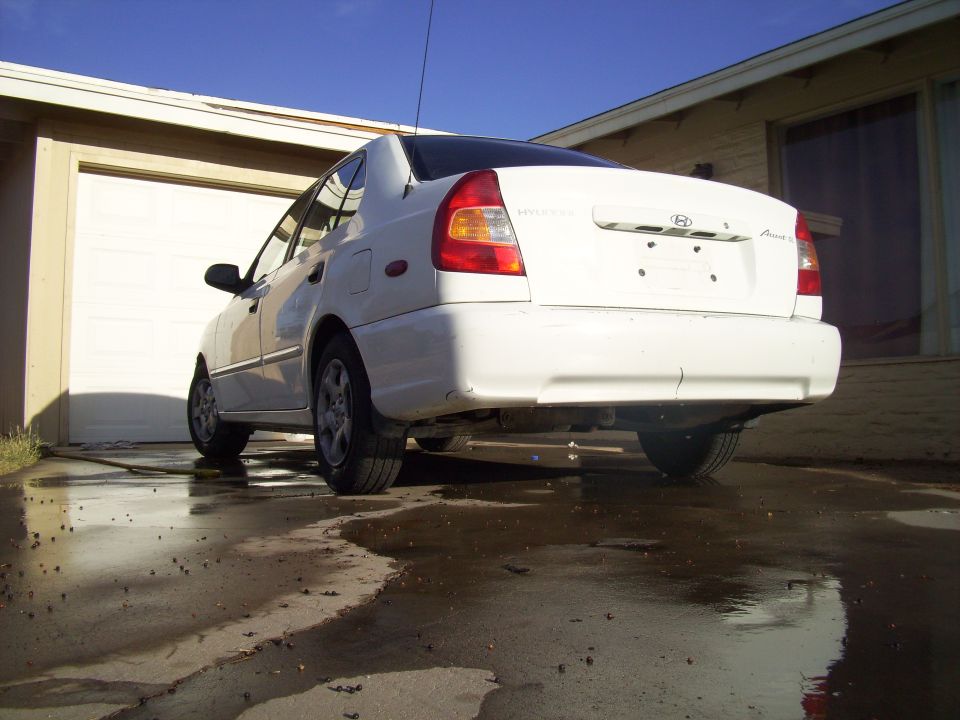 Rear view of a white sedan parked in a driveway
