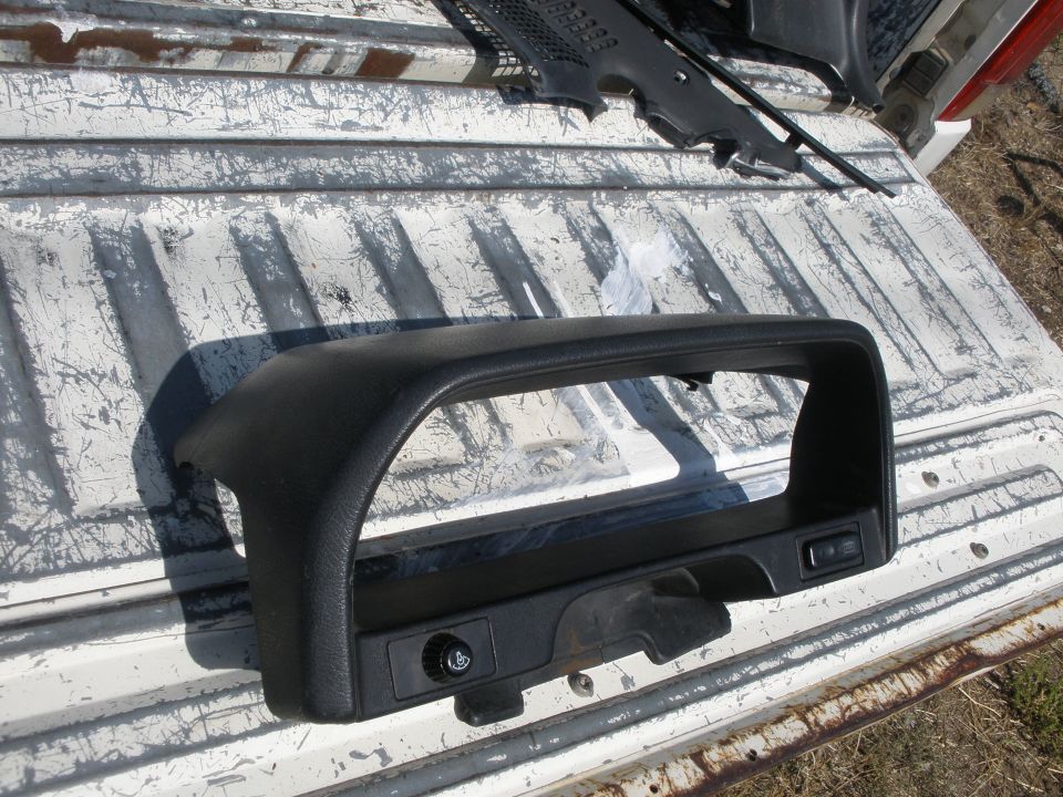 Black dashboard trim piece with switch cutout