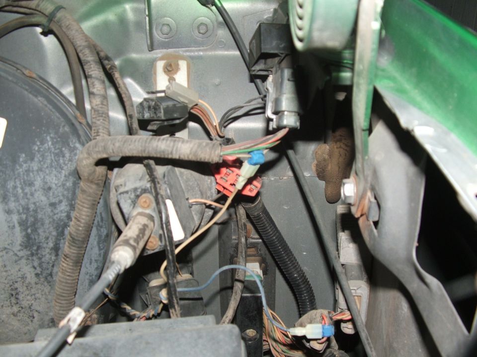 Vehicle wiring harness with red and blue connectors, gray and black conduits, and exposed wires