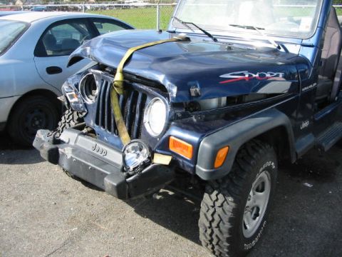 2002 Jeep Wrangler - This Jeep Wrangler sustained front-end damage, with a strap securing the hood after the impact.