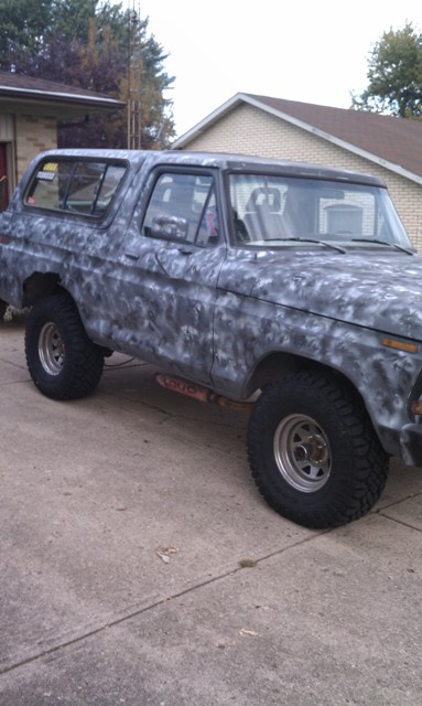 1978 Ford Bronco - This Ford Bronco has a unique camouflage paint scheme and is parked on a concrete driveway.