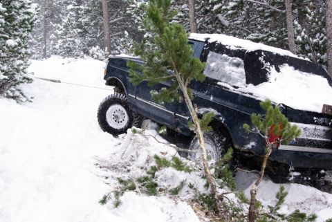 1996 Ford Bronco - A 1996 Ford Bronco is being pulled from a snowy embankment in a wooded area.