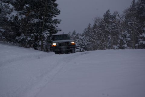 1996 Ford Bronco - A 1996 Ford Bronco navigates a snow-covered path through a wooded area.