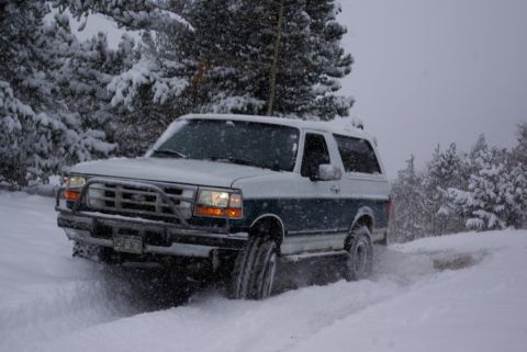 1996 Ford Bronco - This two-tone Ford Bronco navigates a snowy trail, equipped with a front brush guard.