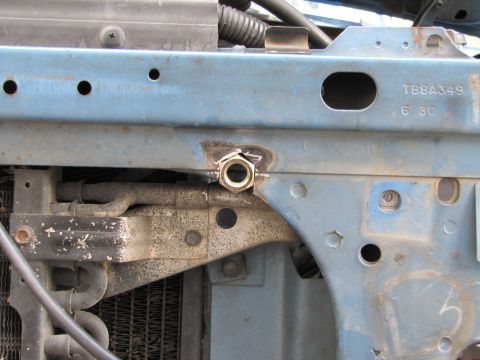 1993 Ford F-250 - This image shows a close-up view of the engine bay, focusing on the metal framework and some hoses, with a welded nut on a bracket.