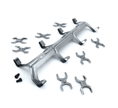 1990 Ford Bronco - A collection of metal exhaust manifold components and fasteners are arranged on a white surface.