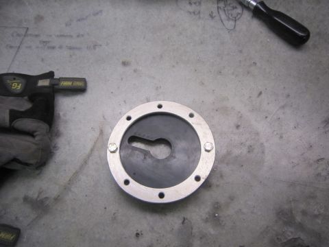 1974 Ford Bronco - A fuel filler cap is shown on a workbench with a glove and tool nearby.