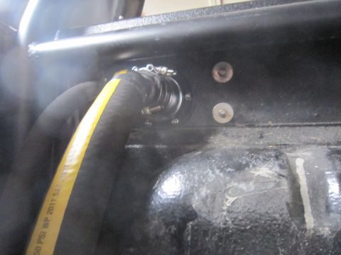 1974 Ford Bronco - A hose connects to a fuel filler neck assembly, showing visible text on the hose.