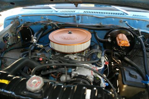 1978 Ford Bronco - Close-up view of the engine compartment, showing various hoses, wires, and the air intake system.