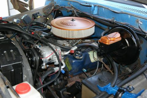 1978 Ford Bronco - Close-up of an engine bay, a copper-colored air filter housing and a black brake booster assembly.