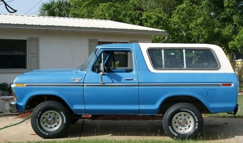 1978 Ford Bronco - Side view of a blue 1978 Ford Bronco with a white hardtop, parked on a driveway.