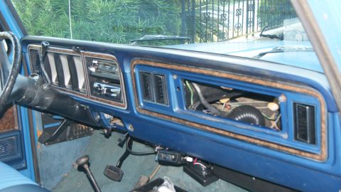 1978 Ford Bronco - The interior of a 1978 Ford Bronco shows a blue dashboard with wood grain accents and exposed components.