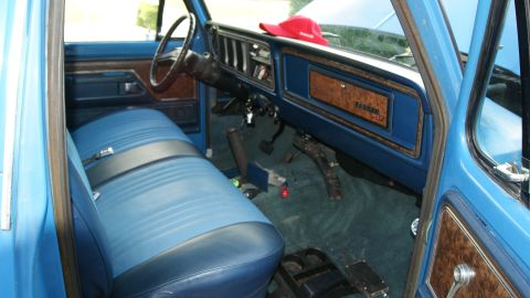 1978 Ford Bronco - Interior view of a 1978 Ford Bronco, showing the blue seats, dashboard, and wood grain accents.