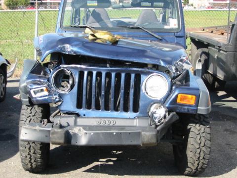 2002 Jeep Wrangler - This heavily damaged Jeep Wrangler shows significant front-end collision impact.