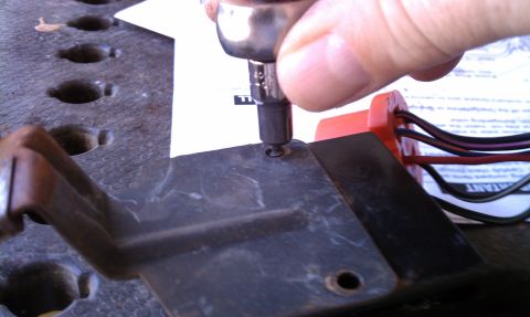 1990 Ford Bronco - A hand uses a socket wrench to secure a part during a wiper repair.