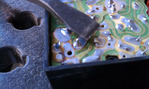 1990 Ford Bronco - A tool is used to work on the solder points of a circuit board.