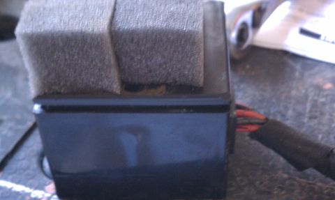 1990 Ford Bronco - Close-up of a vehicle wiper motor component, showing wiring and foam insulation.