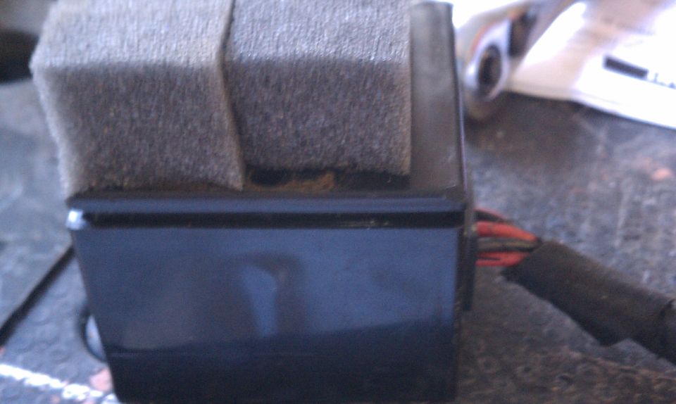 Black wiper motor housing with foam padding and exposed red and black wires