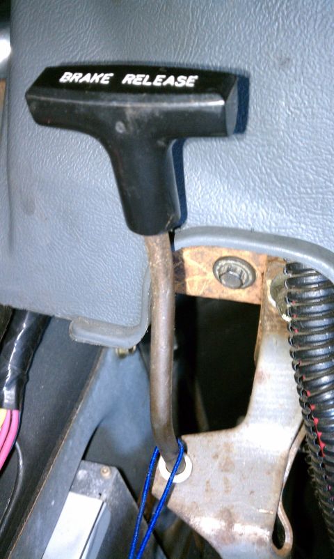 1990 Ford Bronco - Close-up of a brake release lever inside a vehicle's cabin.
