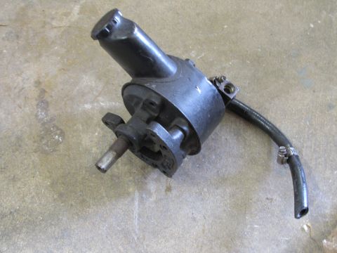 1995 Ford Bronco - A black power steering pump with a hose attached is shown against a concrete background.