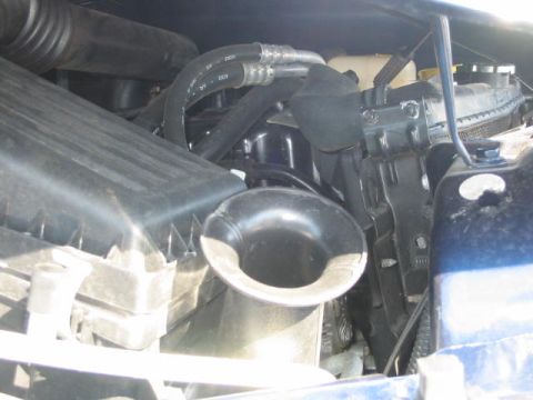 2002 Jeep Wrangler - Close-up view of engine components, including the air intake and radiator, in a blue vehicle.