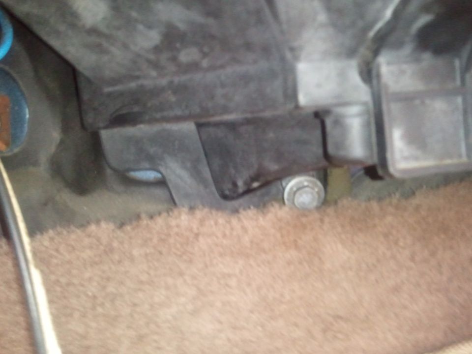 AC system component with bolt and carpeted floor