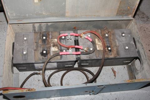 1978 Chevrolet C/K Pickup - A close-up view of a battery bank, showing the wiring and the condition of the batteries within a metal housing.