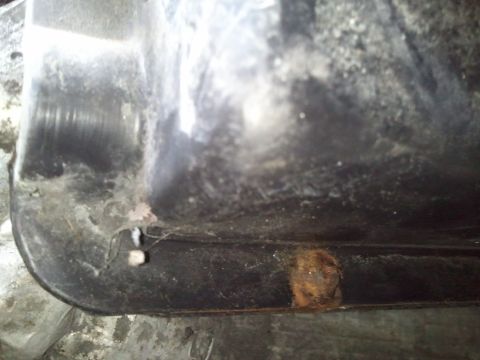 1994 Ford Bronco - This image shows a close-up view of a corroded metal component, likely a vehicle part.
