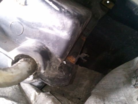 1994 Ford Bronco - A close-up view of a vehicle's undercarriage, focusing on a specific component and attached hose.