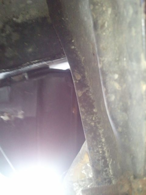 1994 Ford Bronco - Close-up view of the undercarriage, revealing structural elements and a dark tank.