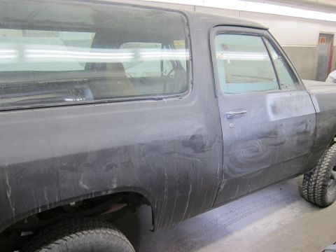 1987 Dodge 1500 - A dusty black Dodge Ramcharger is viewed from the side, likely in a workshop.