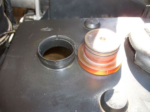 1996 Ford Bronco - The cap for an engine fluid reservoir sits next to the open container.