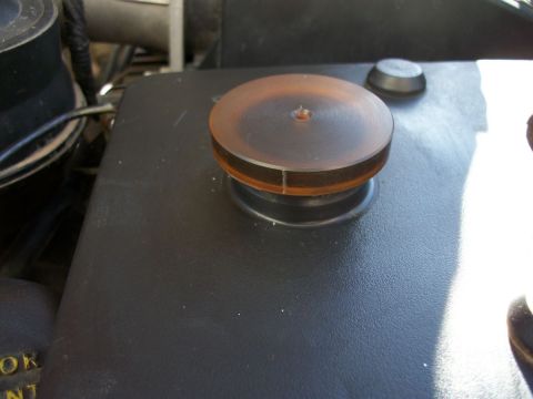 1996 Ford Bronco - Close-up of a vehicle's engine compartment, focusing on a cap and button.