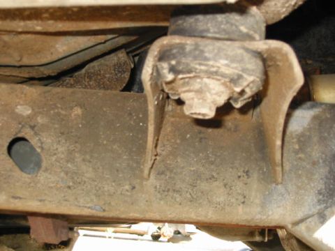 2002 Jeep Wrangler - The underside of a vehicle reveals a damaged mounting bracket and extensive rust on the frame components.