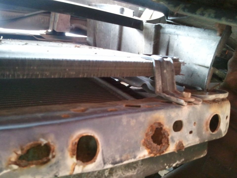 rusted out radiator support on a vehicle