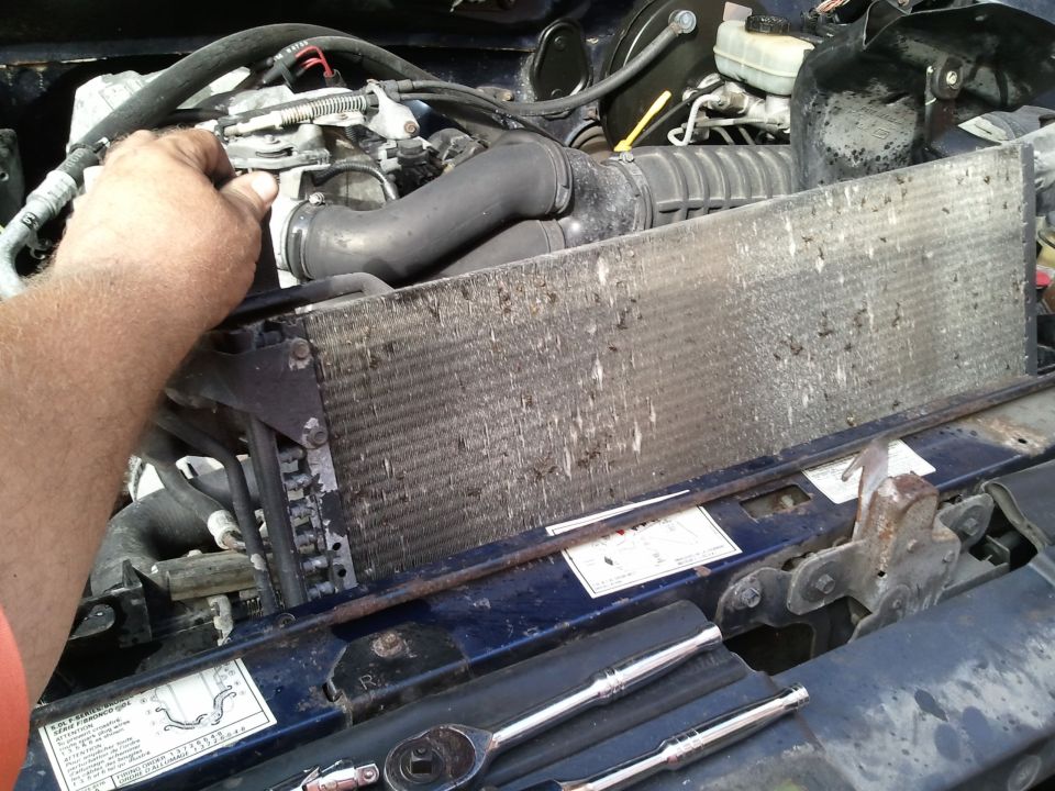 1994 Ford Bronco engine bay, dirty radiator being worked on