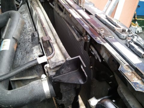 1994 Ford Bronco - Vehicle radiator and AC condenser assembly with associated hoses and hardware. Tools are present on the upper frame.